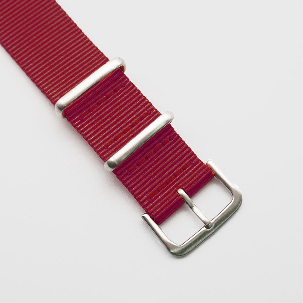 Spännet till ett rött natoband i borstad stål.