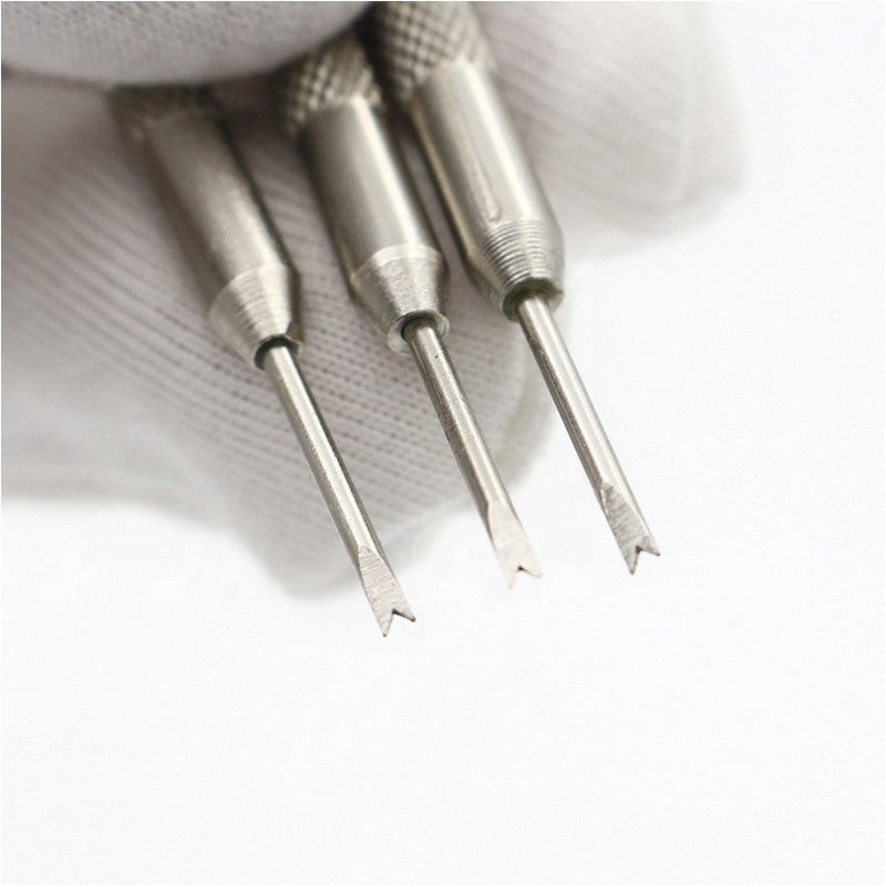 Hand som håller tre klockverktyg.